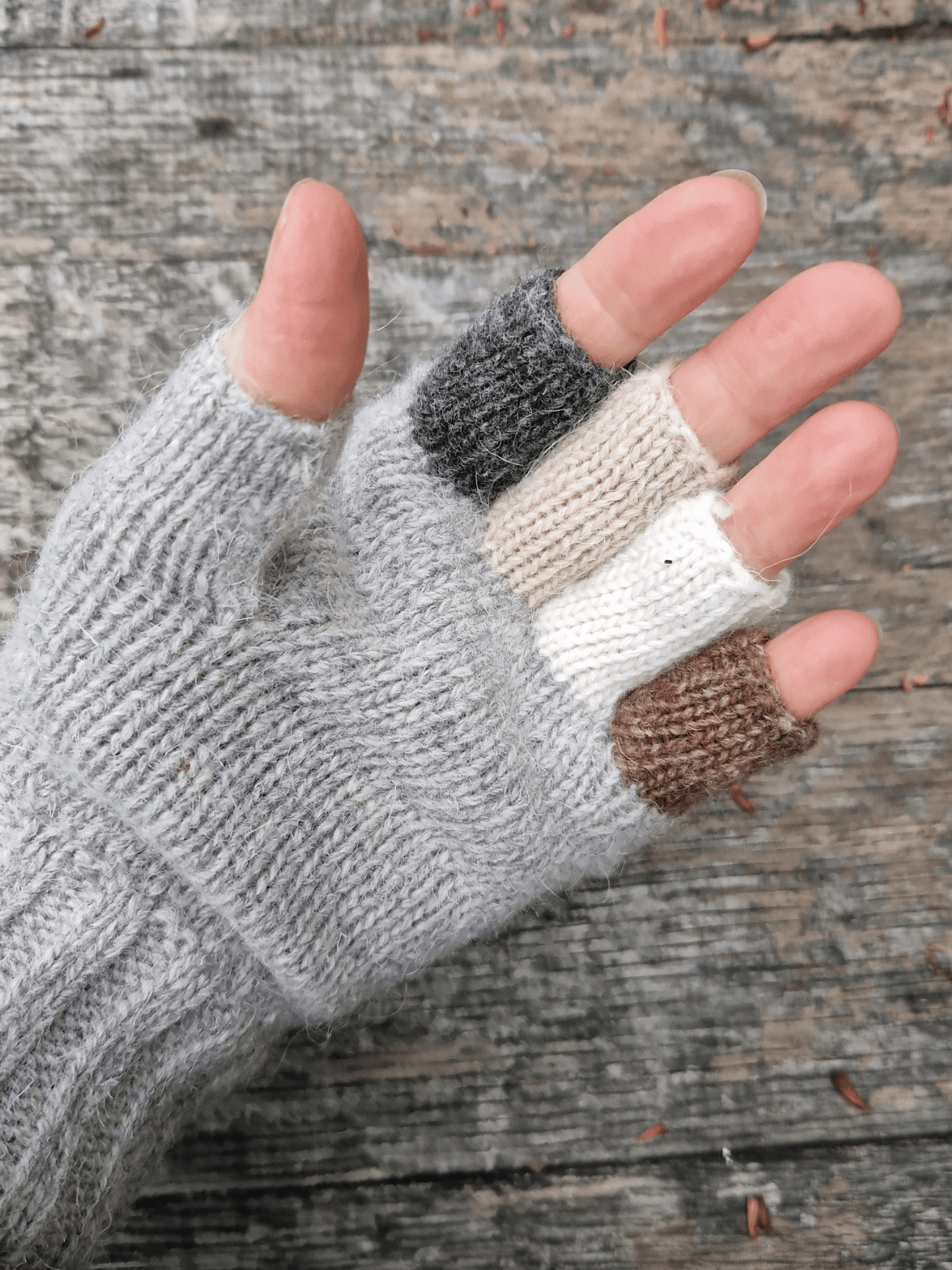 hand wearing knitted fingerless gloves