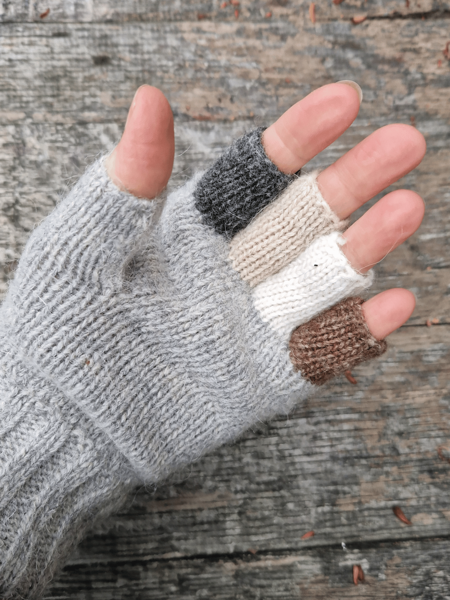 hand wearing knitted fingerless gloves