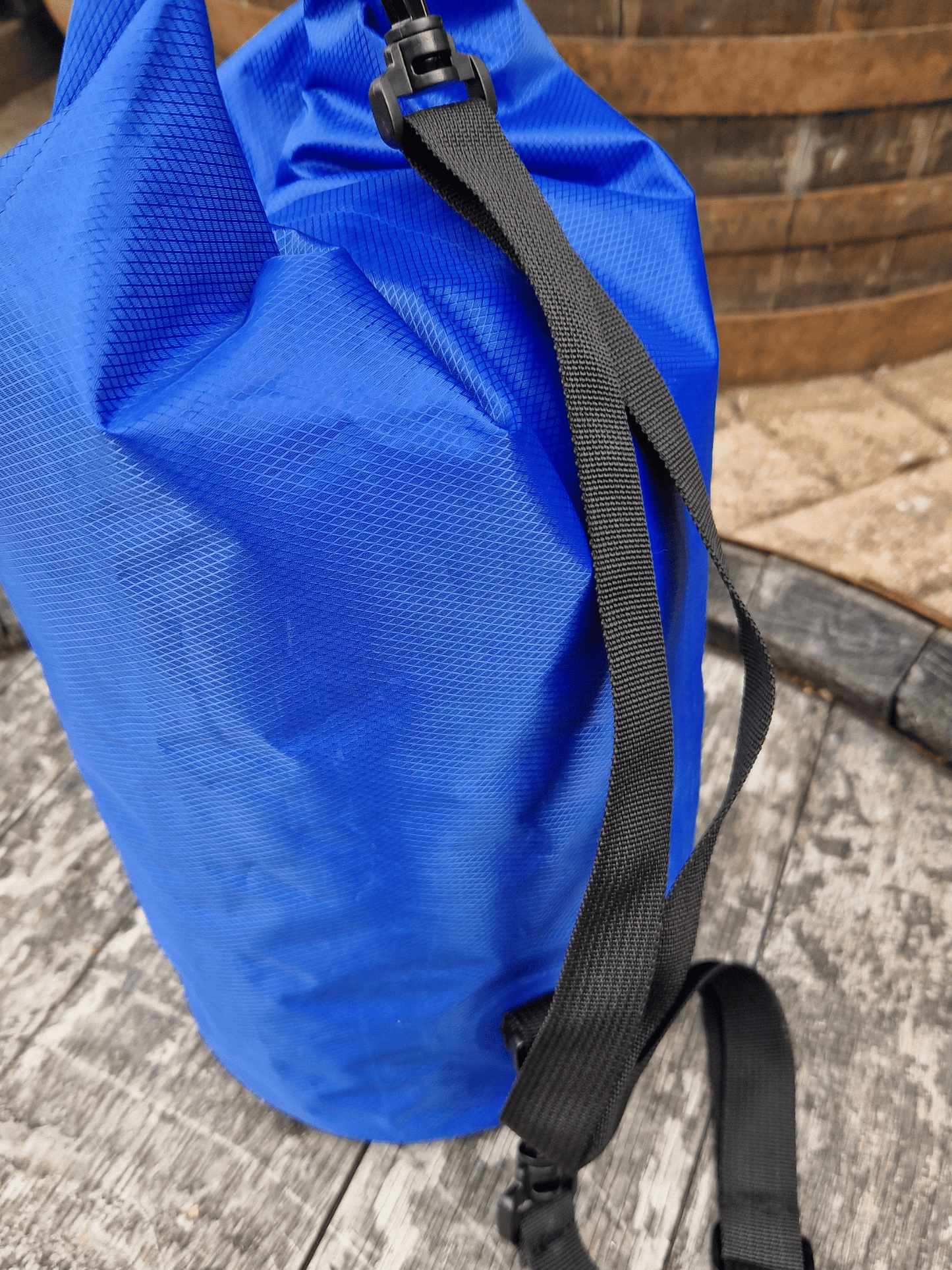 close up of blue dry bag, showing the shoulder strap