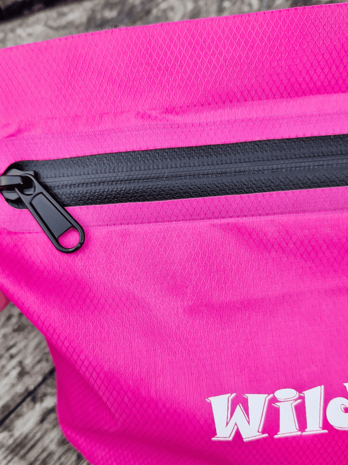 close up of pink bag with a black water-resistant zipper on a wooden surface