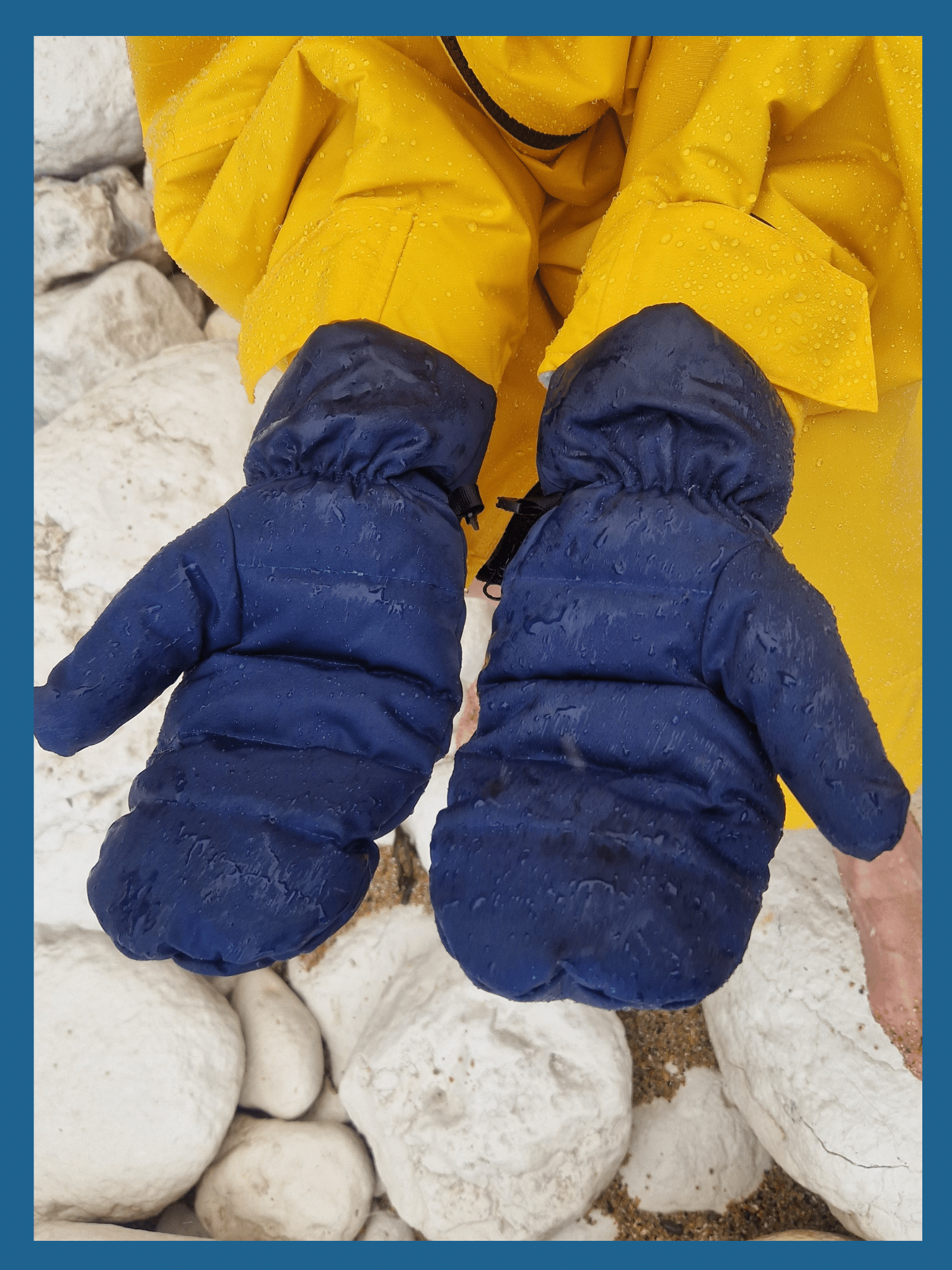 a close up shot of a pair of navy coloured waterproof mittens. You can see the moisture on the exterior of the gloves