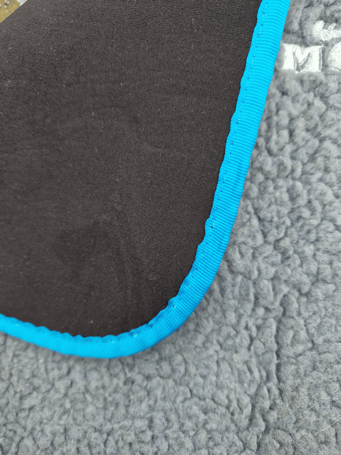 the corner of a fleece-topped changing mat folded over to show the neoprene base layer