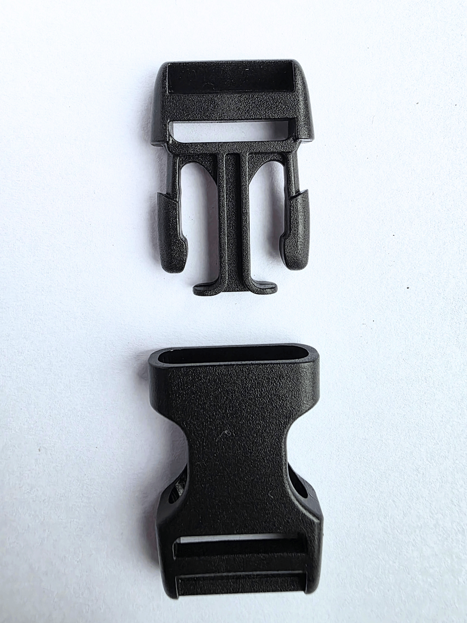 the two separated elements of a black plastic side release buckle
