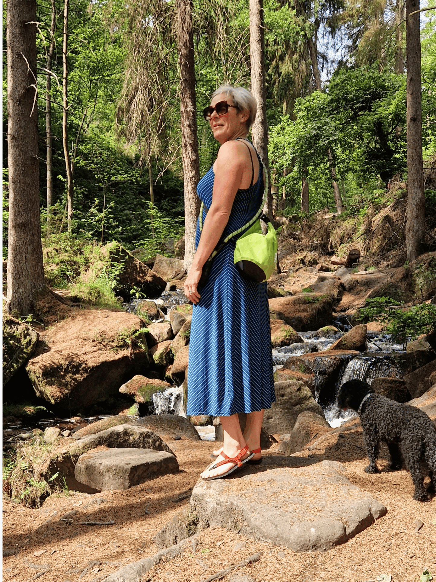 lady in a summer dress in woodland area with green 5L dry bag over shoulder