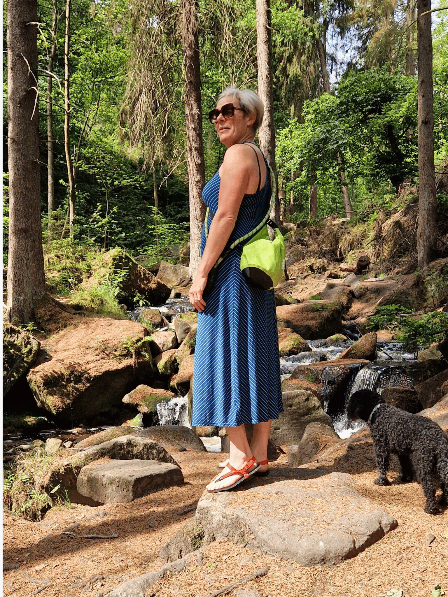 lady in a summer dress in woodland area with green 5L dry bag over shoulder