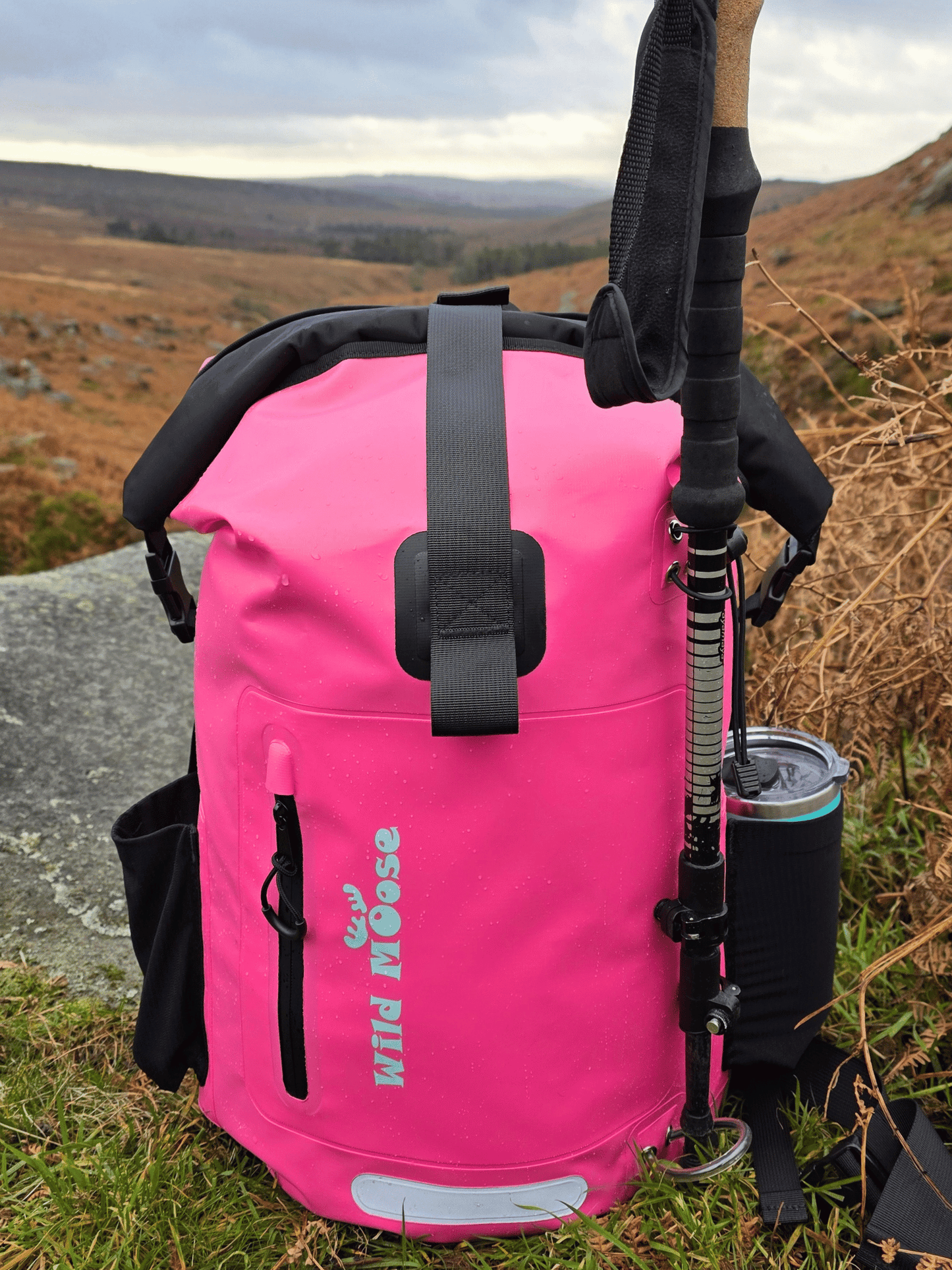 Pink backpack with outdoor gear on a natural landscape