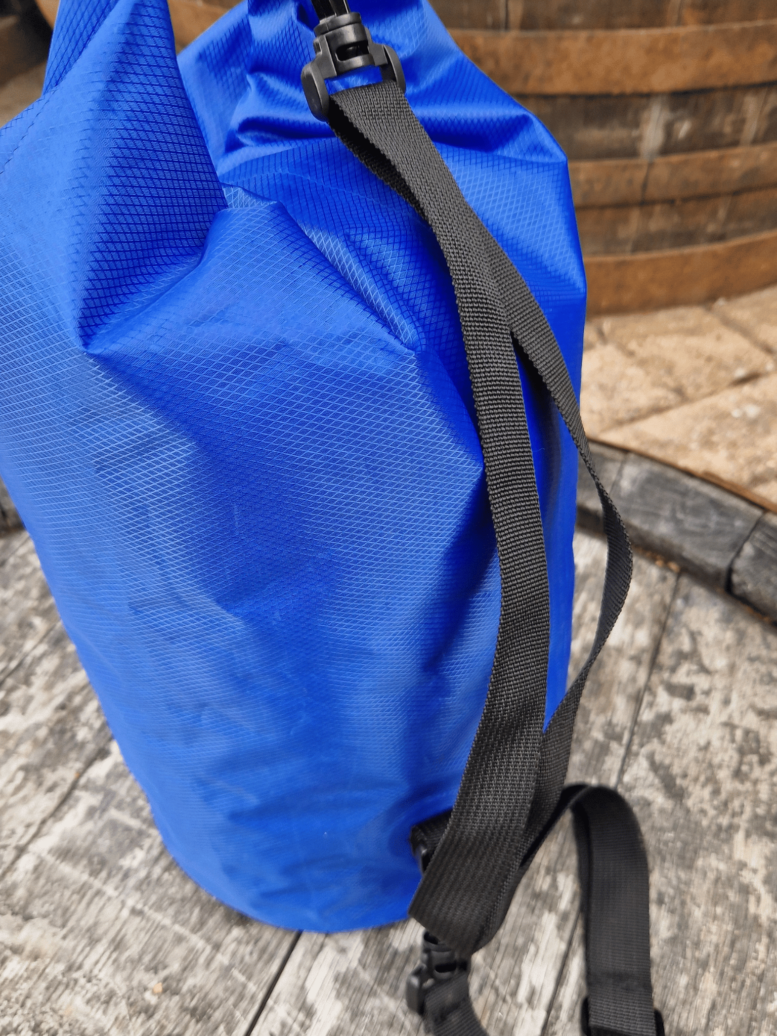 close up of blue dry bag, showing the shoulder strap