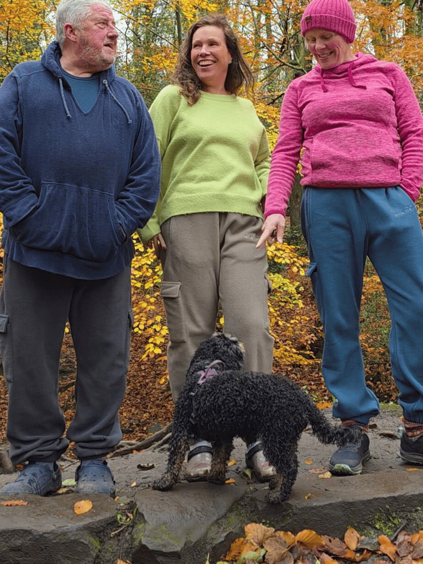 Three people wearing fleece jogging pants with autumn foliage in the background