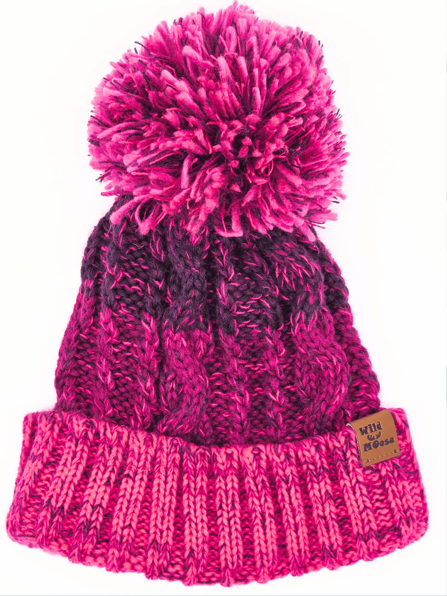 pink and purple knitted beanie with a purple and pink pompom on a white background.