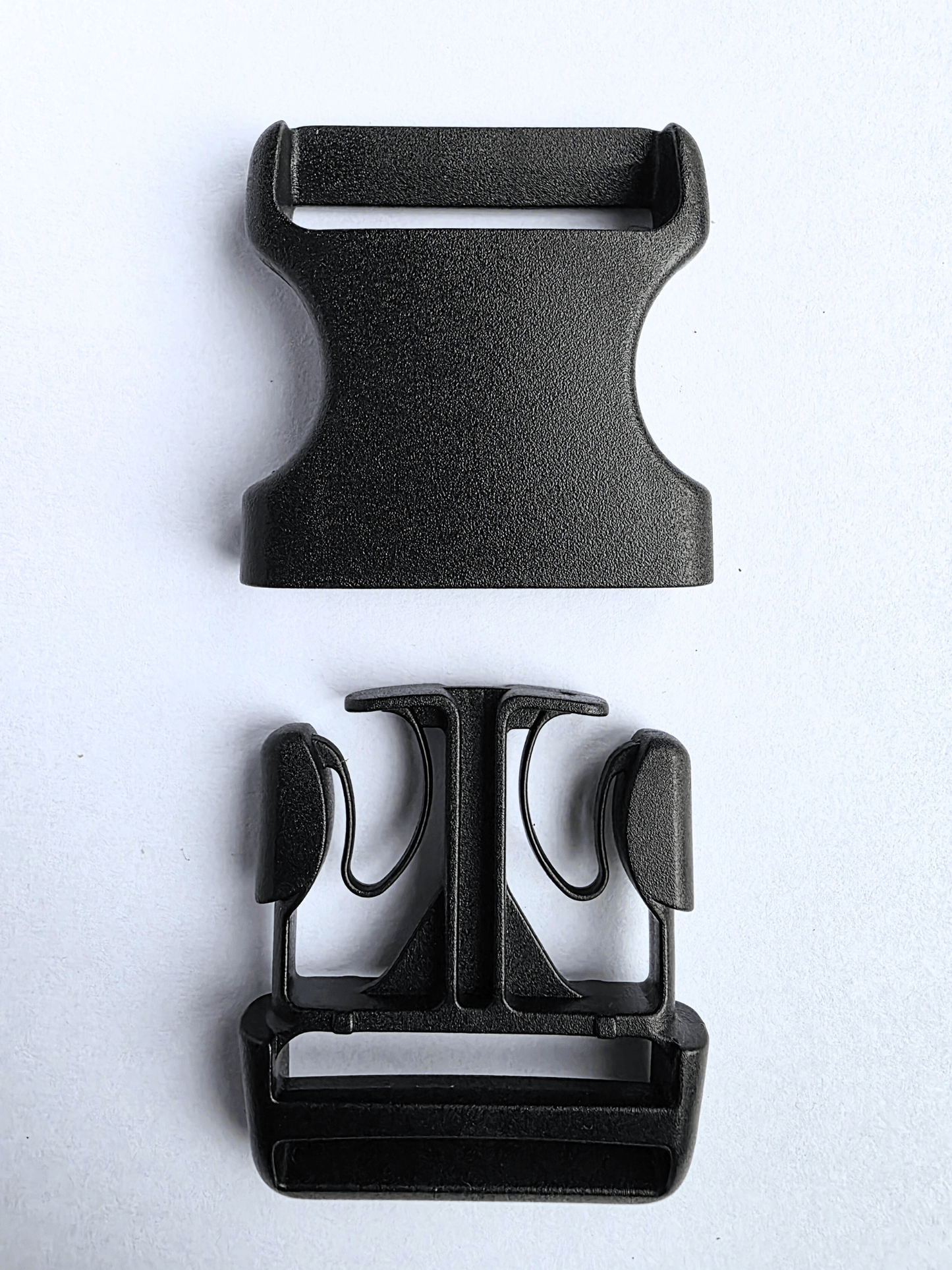 Black, plastic side release buckle separated into 2 parts