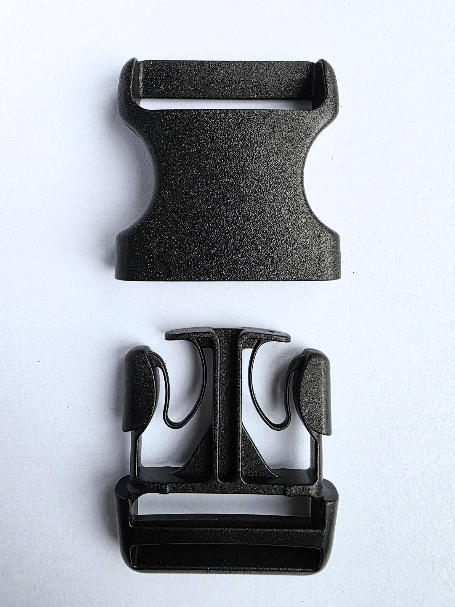 Black, plastic side release buckle separated into 2 parts