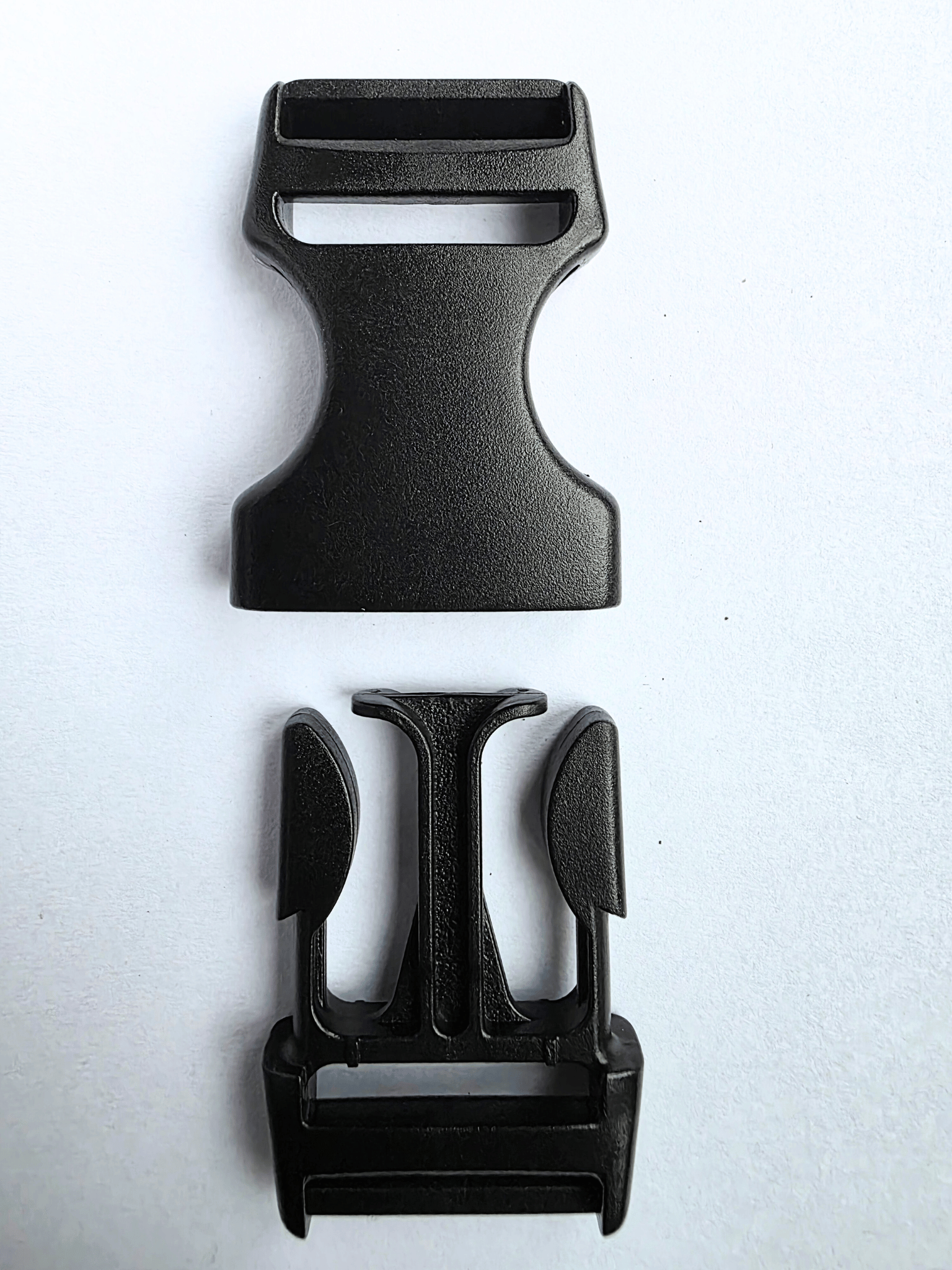 Black, plastic side release buckle shown as 2 separate elements